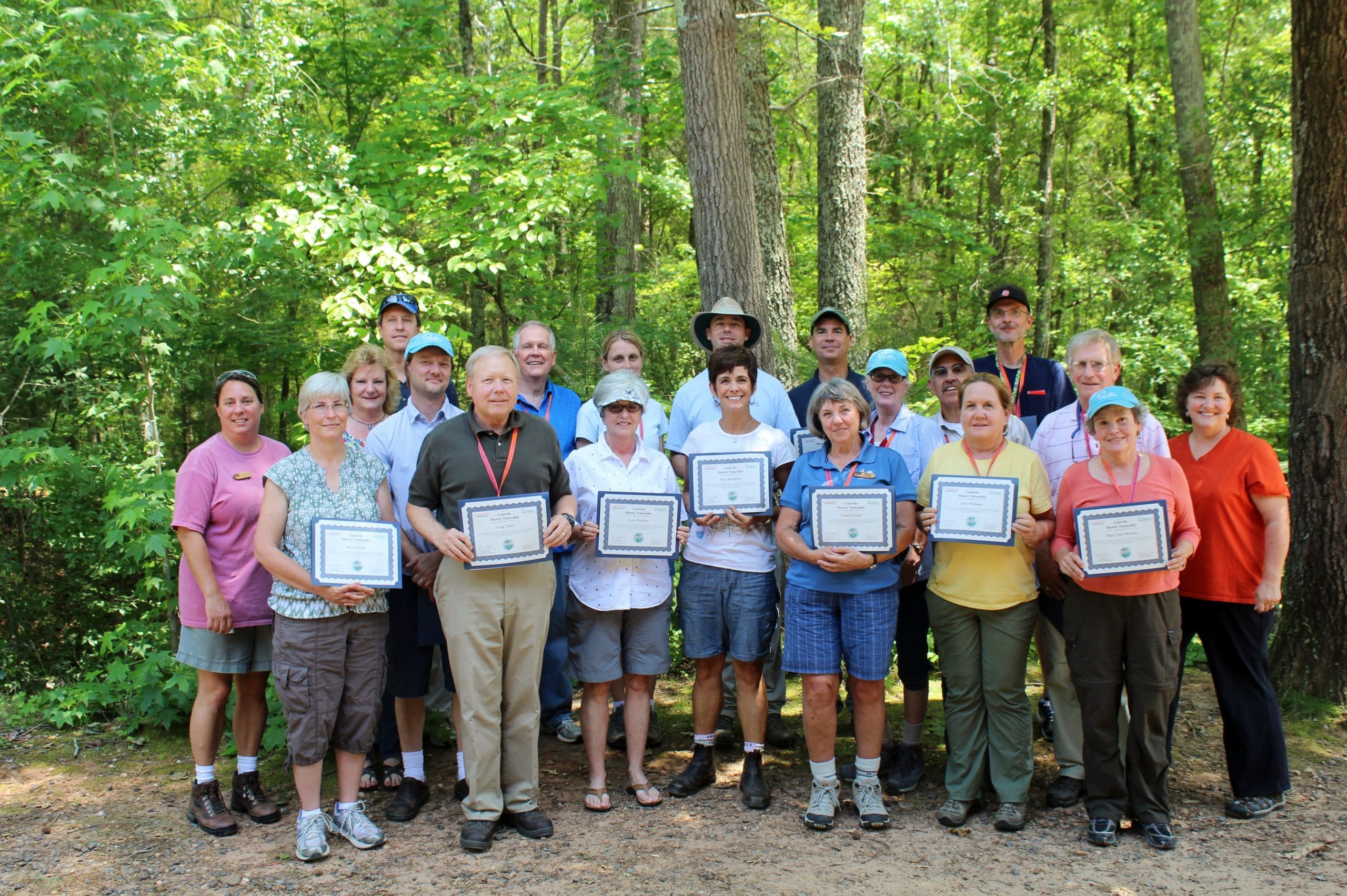 alt=Photo of students of the Catawba Naturalist Program posing and smiling with their certificates outside of the Anne Springs Close Greenway
