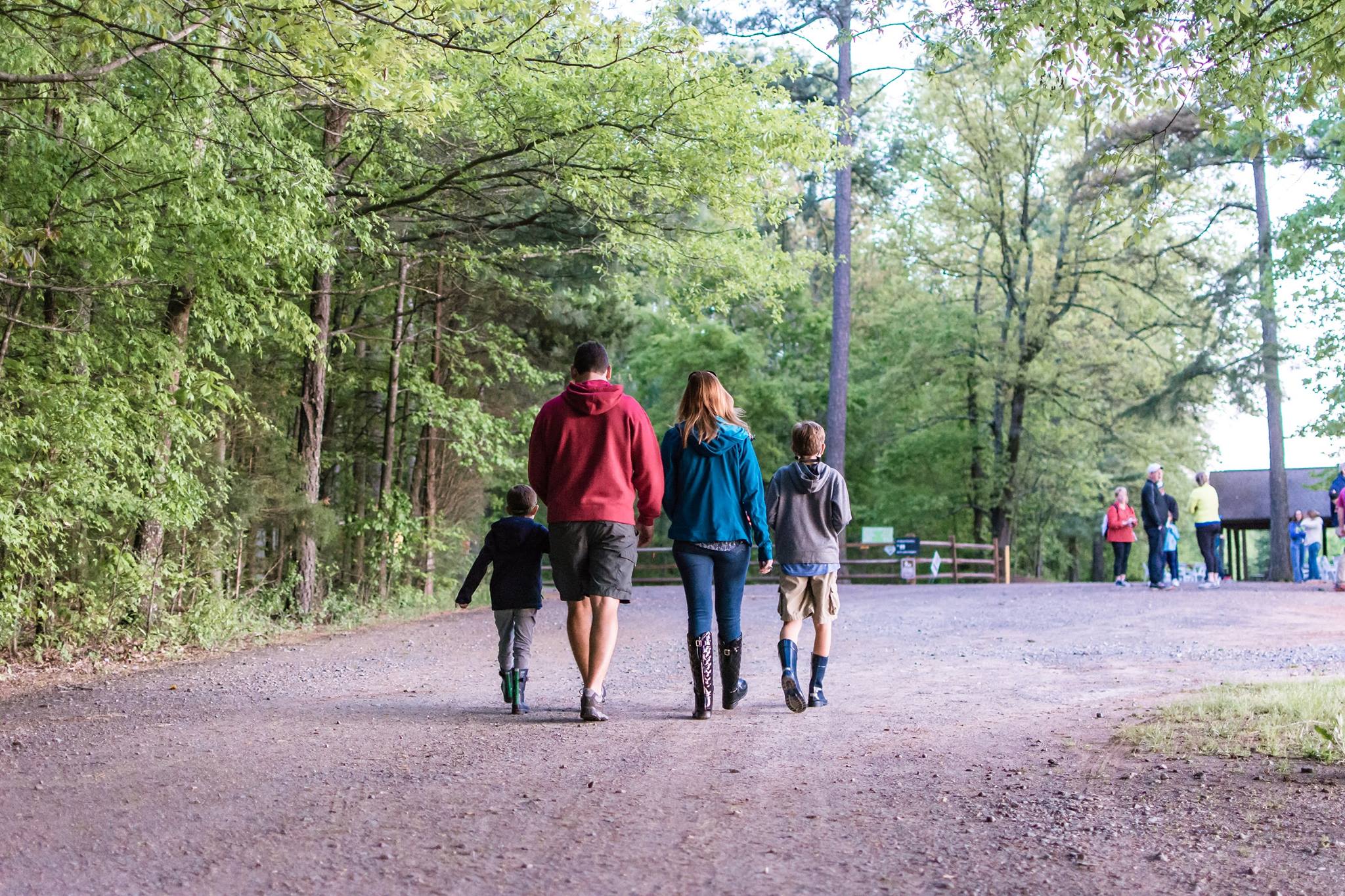 alt=Photo of family walking down a path at the Anne Springs Close Greenway