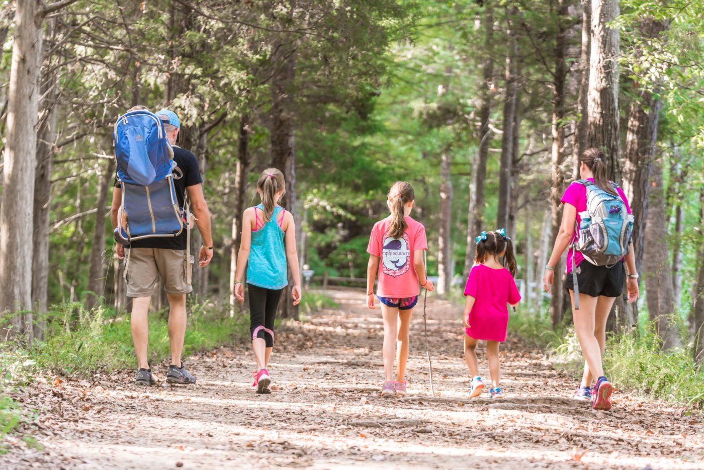 alt=Family hiking down a path in the Greenway