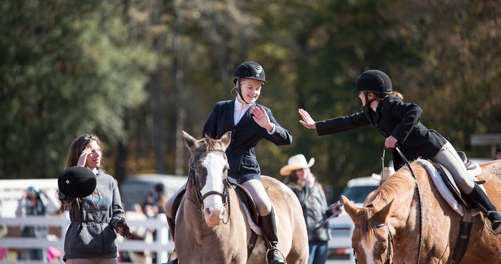 Girls giving high five at horse show