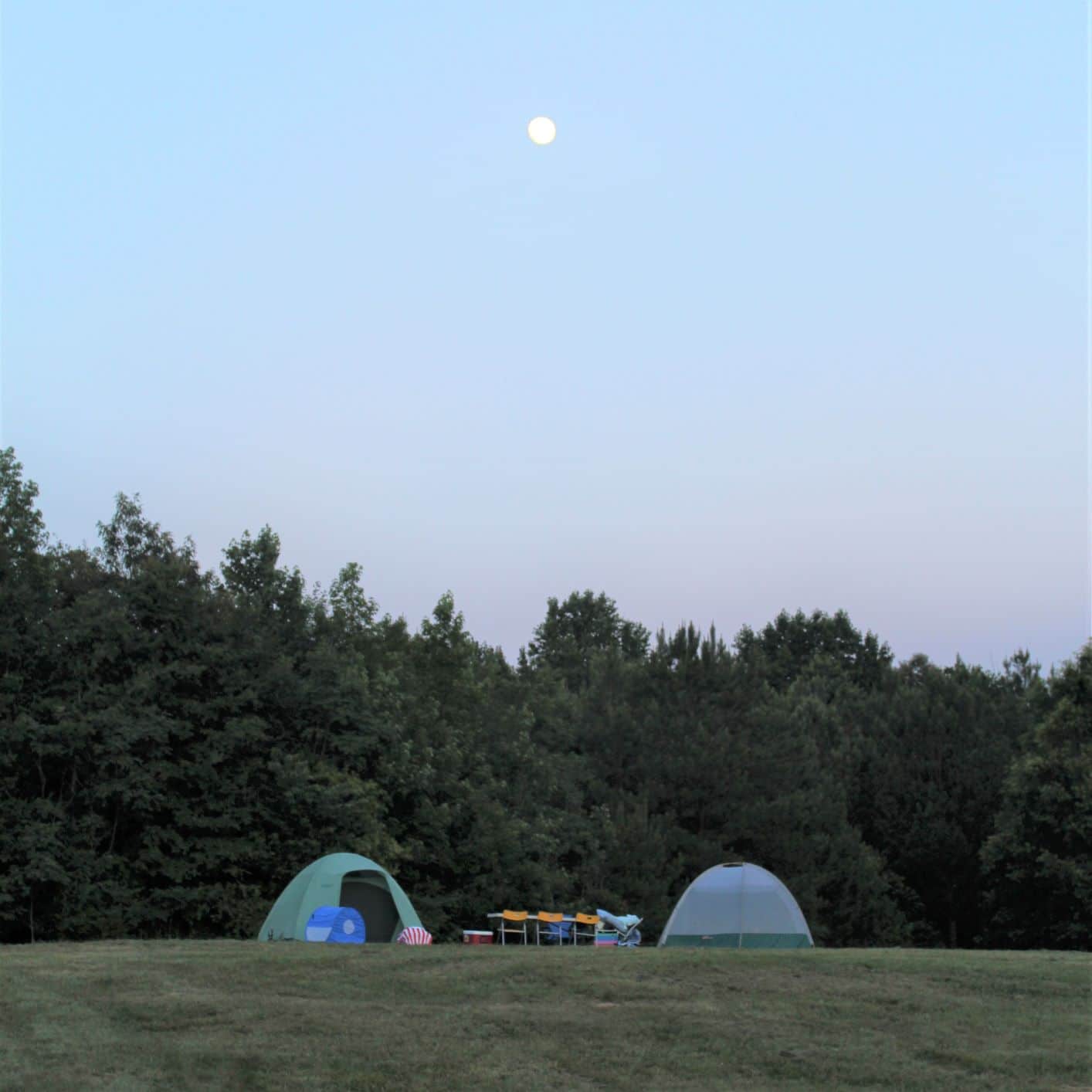 Photo of moon rising over 2 camping tents at the Anne Springs Close Greenway