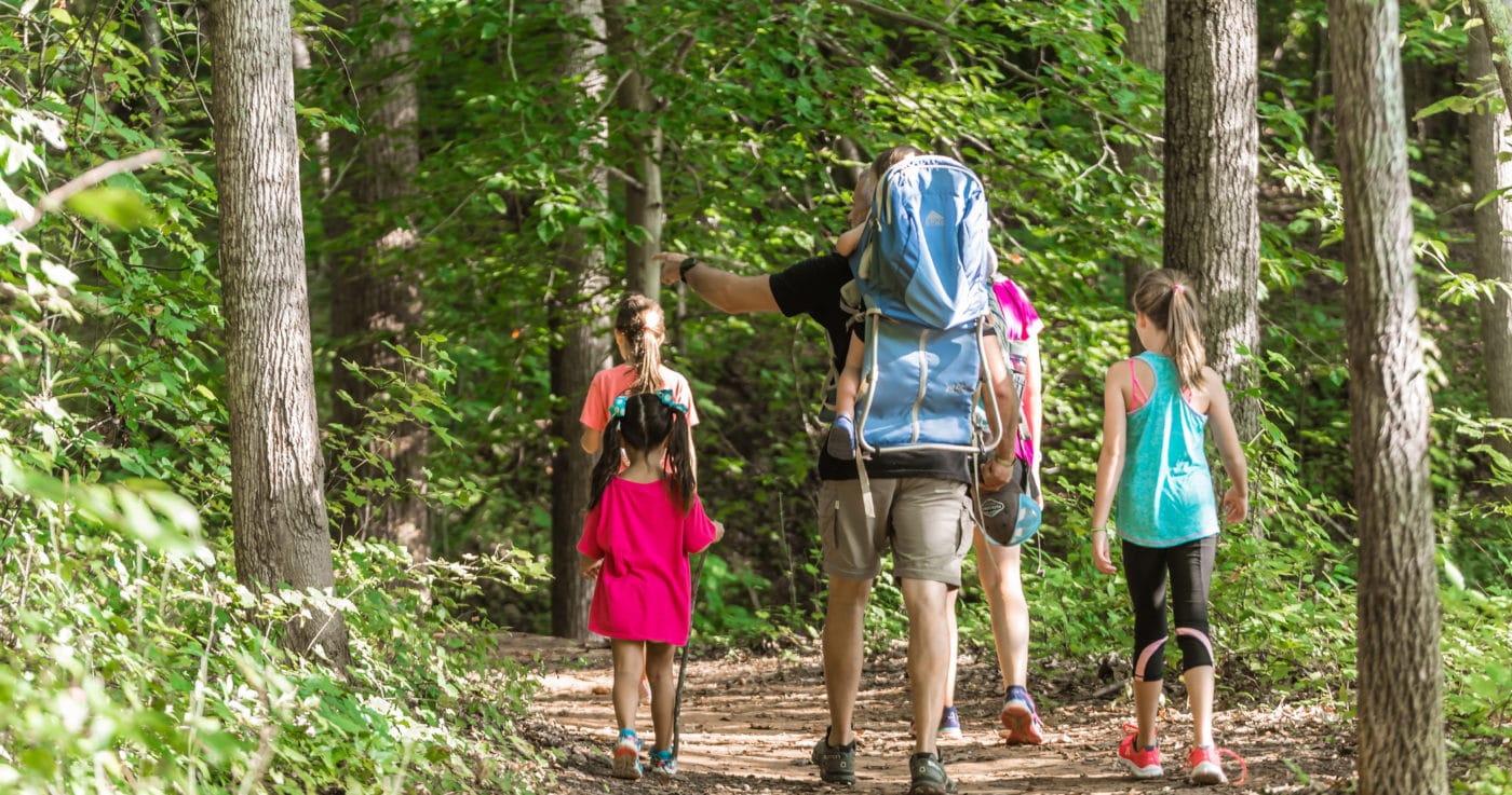 Photo of mother and father hiking with their children around the Haigler Loop trail at the Anne Springs Close Greenway