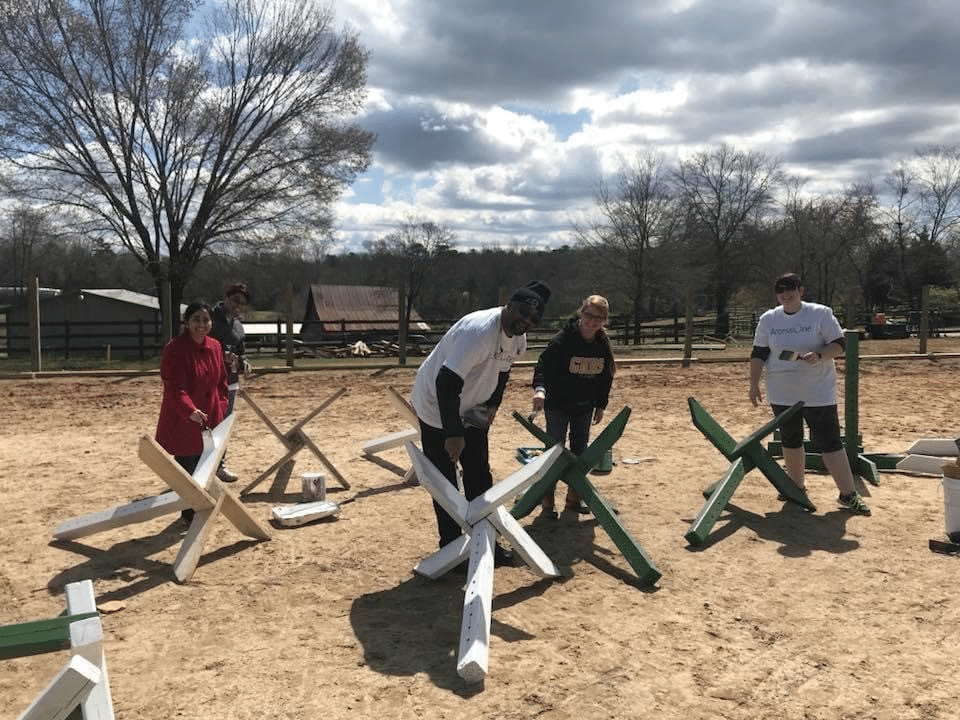 alt=Photo of volunteers assembling barn equipment to use at the Greenway Stables