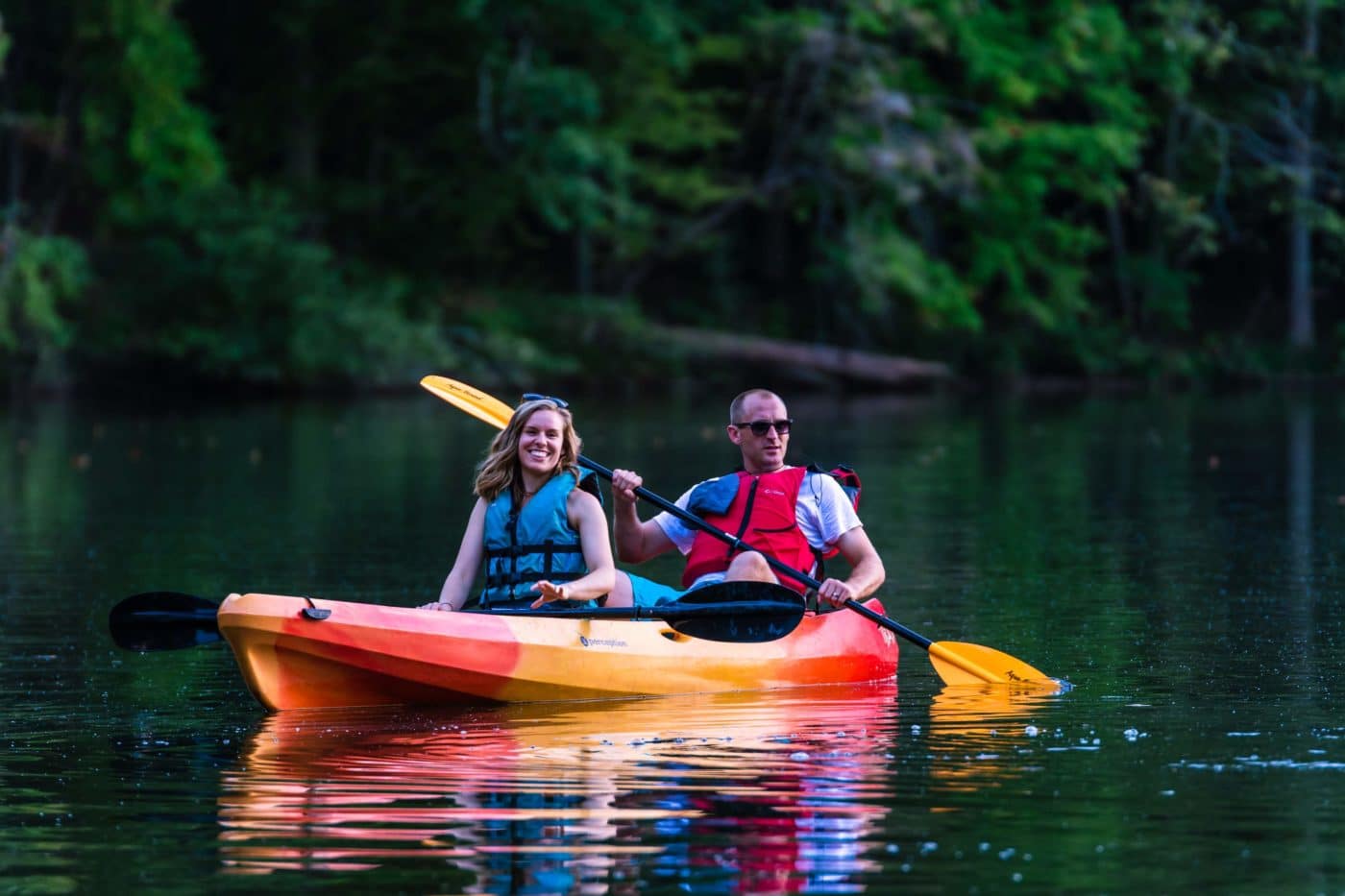 alt=Photo of couple smiling while kayaking on Lake Haigler at the Anne Springs Close Greenway
