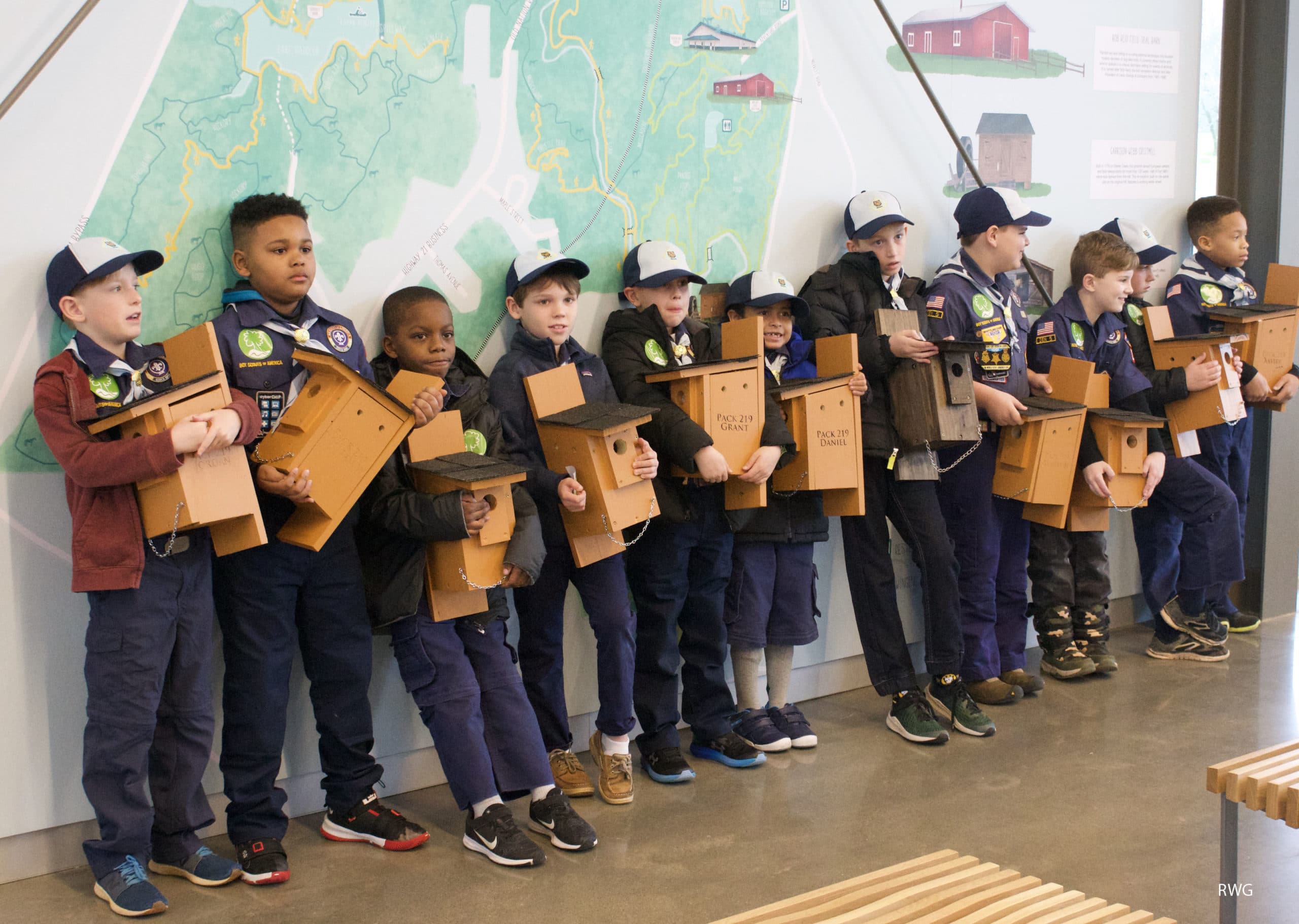 Photo of scout troop posing with DIY birdhouses at the Greenway Gateway at the Anne Springs Close Greenway