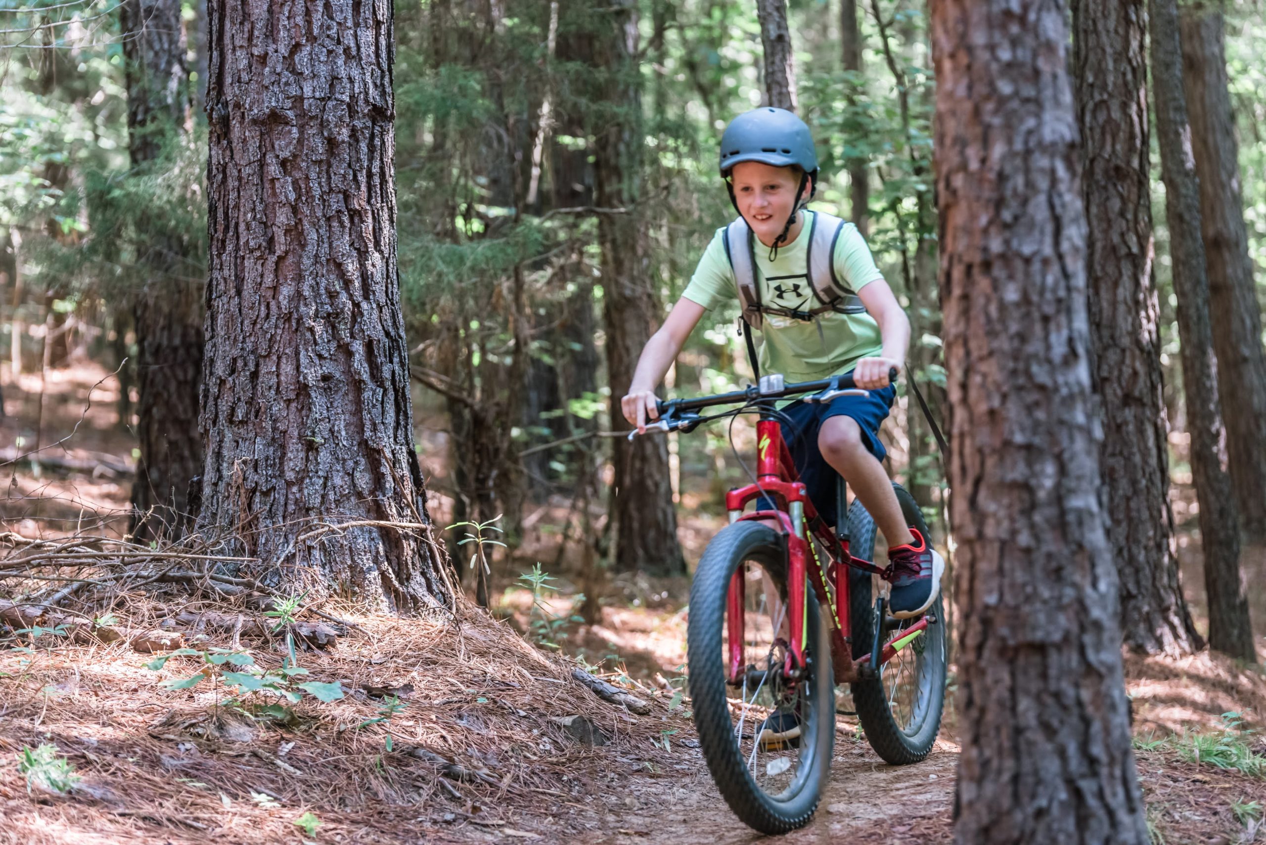 Photo of young boy mountain biking through the trails of the Anne Springs Close Greenway