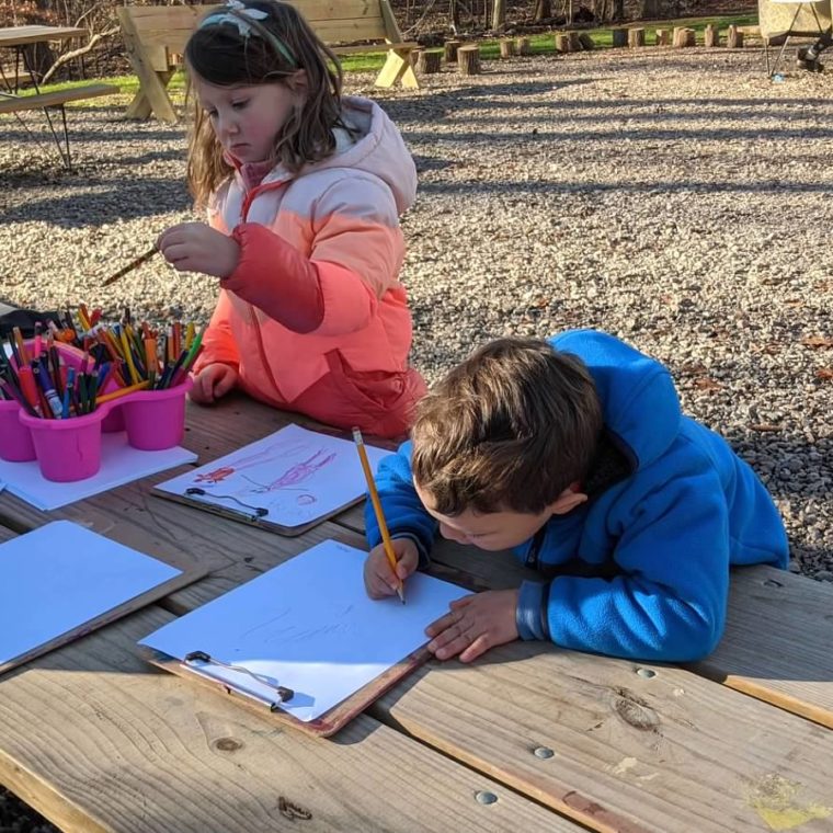 alt=Photo of children coloring outdoors at the Anne Springs Close Greenway