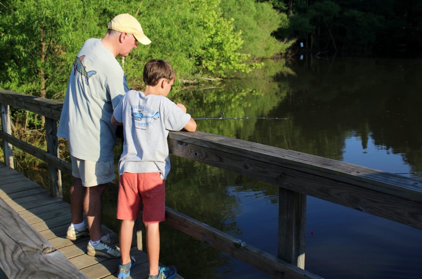 alt=Photo of father and son fishing on the bridge at Lake Haigler