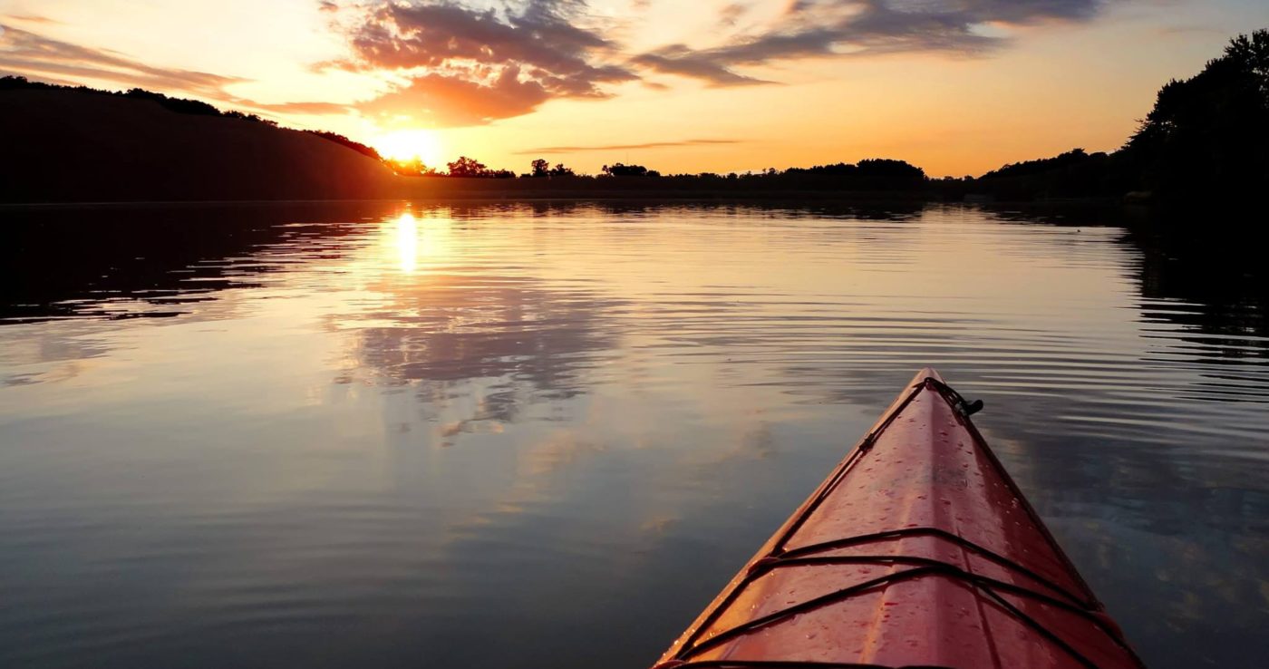 alt=Photo of kayak on Lake Haigler with sun setting