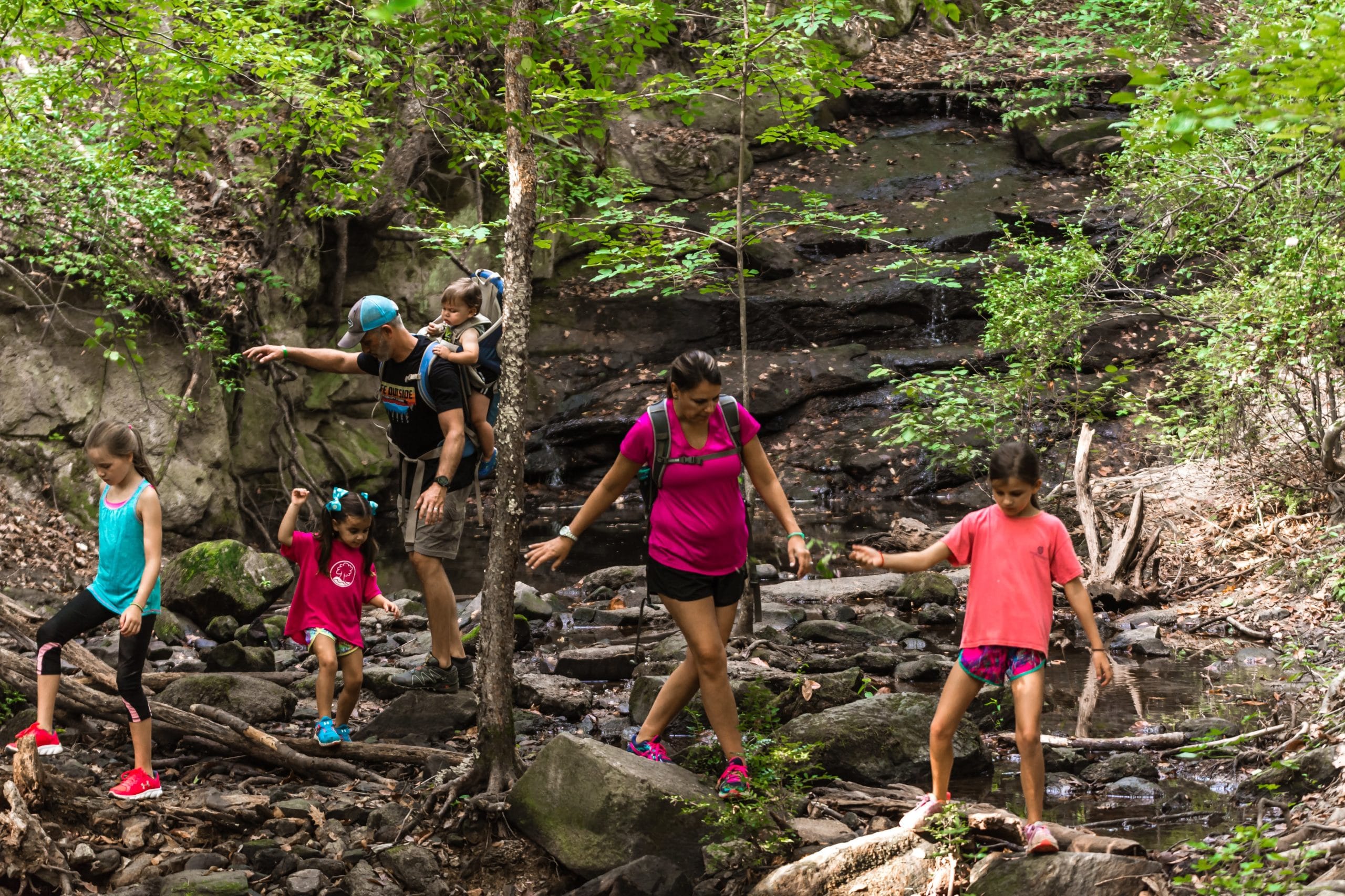 alt=Mother and father hiking with their 4 children at Lake Haigler Spillway