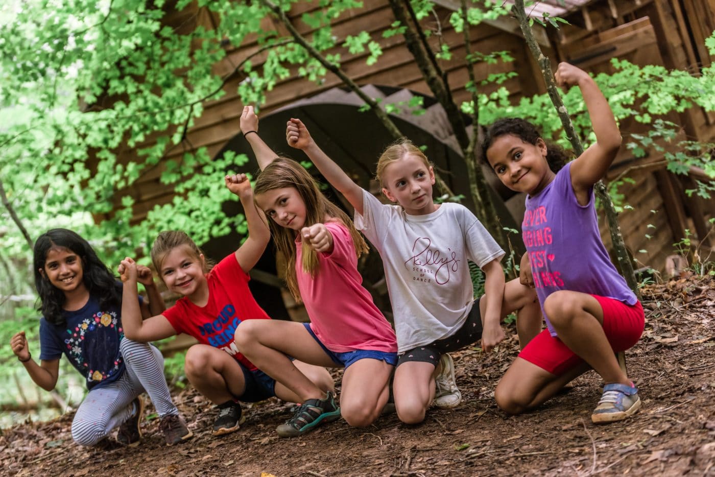 Photo of 5 young girls flexing their arms at Anne Springs Close Greenway's Summer Camp