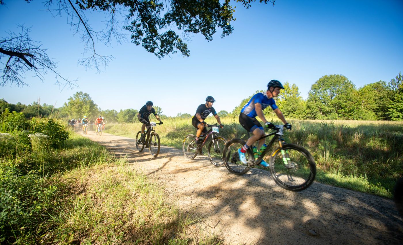 Photo of 3 contestants ahead on the trail at Anne Springs Close Greenway's Tree Shaker Mountain Bike Challenge