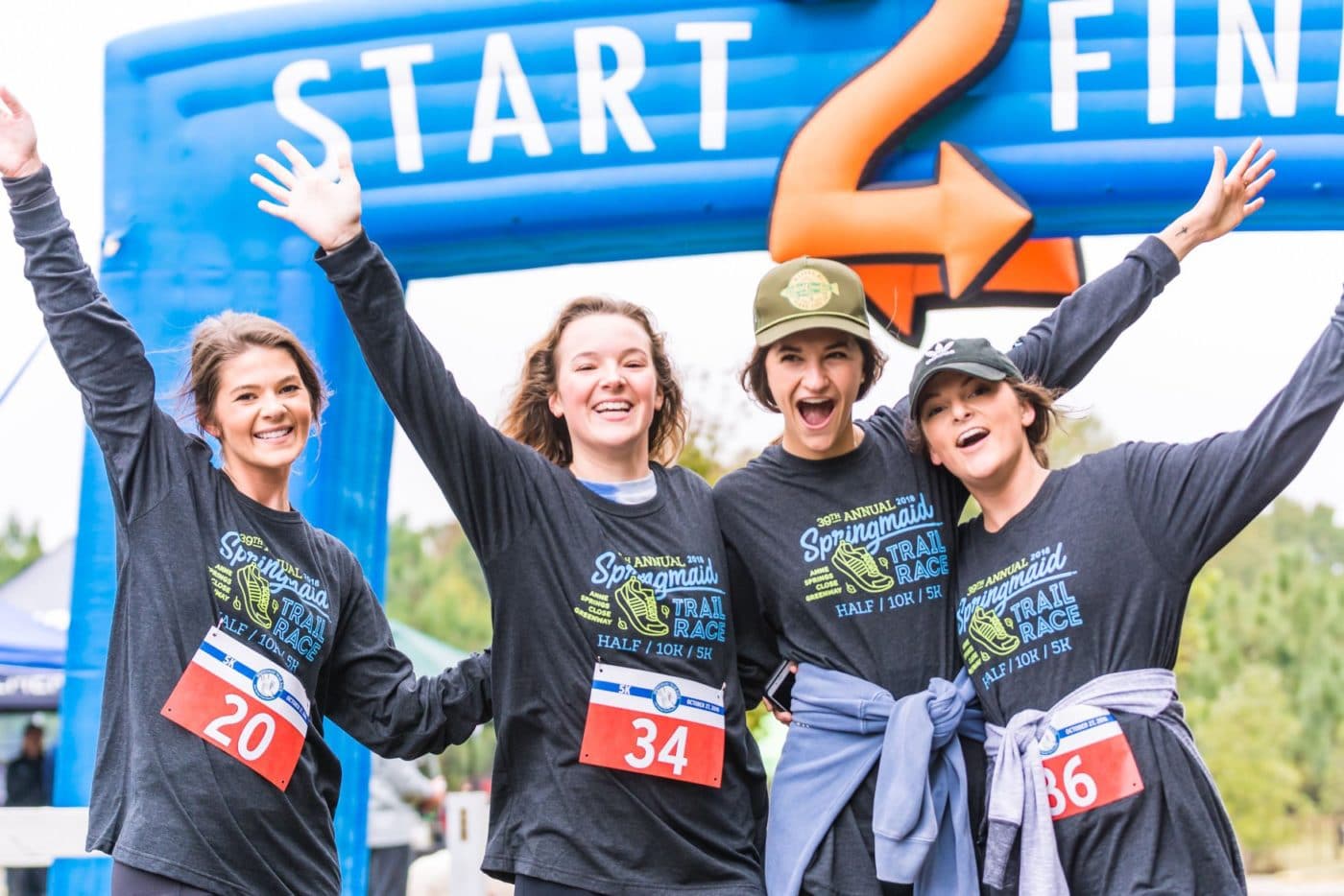 Photo of 4 female runners posing at the finish line of the Springmaid Trail Race at Springmaid Mountain