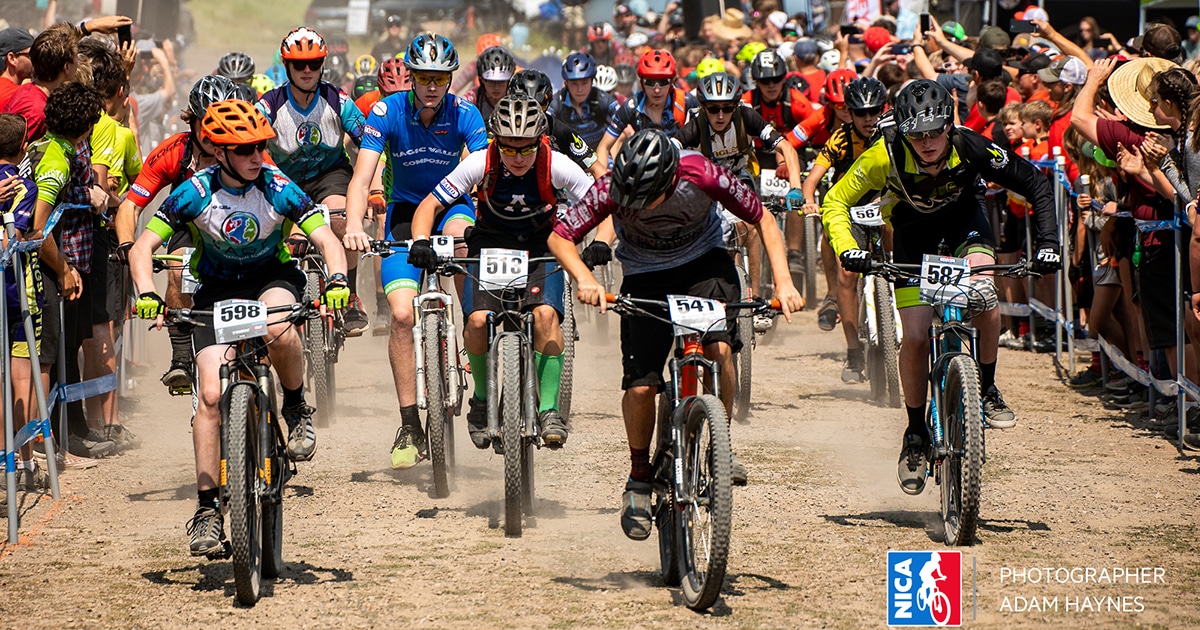 Photo of cyclers taking off at the starting line of the National Interscholastic Cycling Association Mountain Bike Race