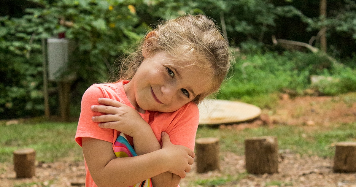 alt=Young girl smiling at the camera at the Anne Springs Close Greenway
