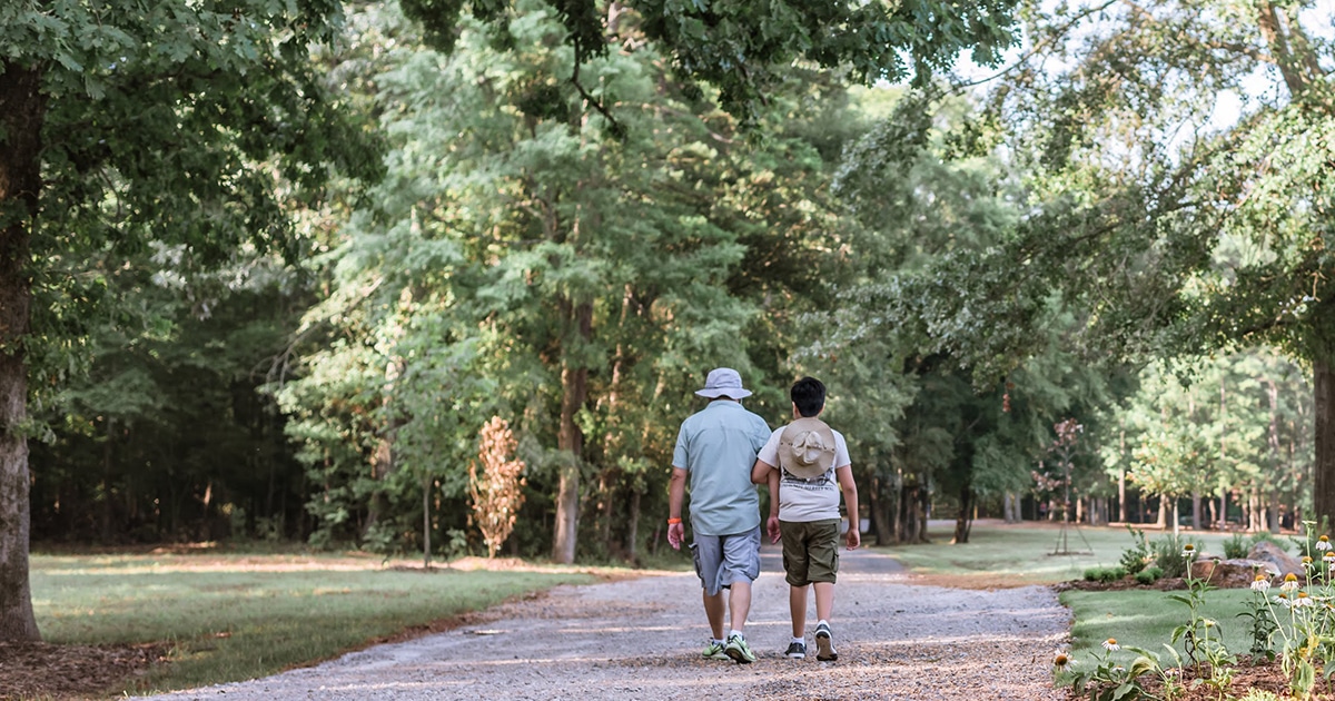 Photo of father and son hiking along the Wagon Loop Trail of the Anne Springs Close Greenway