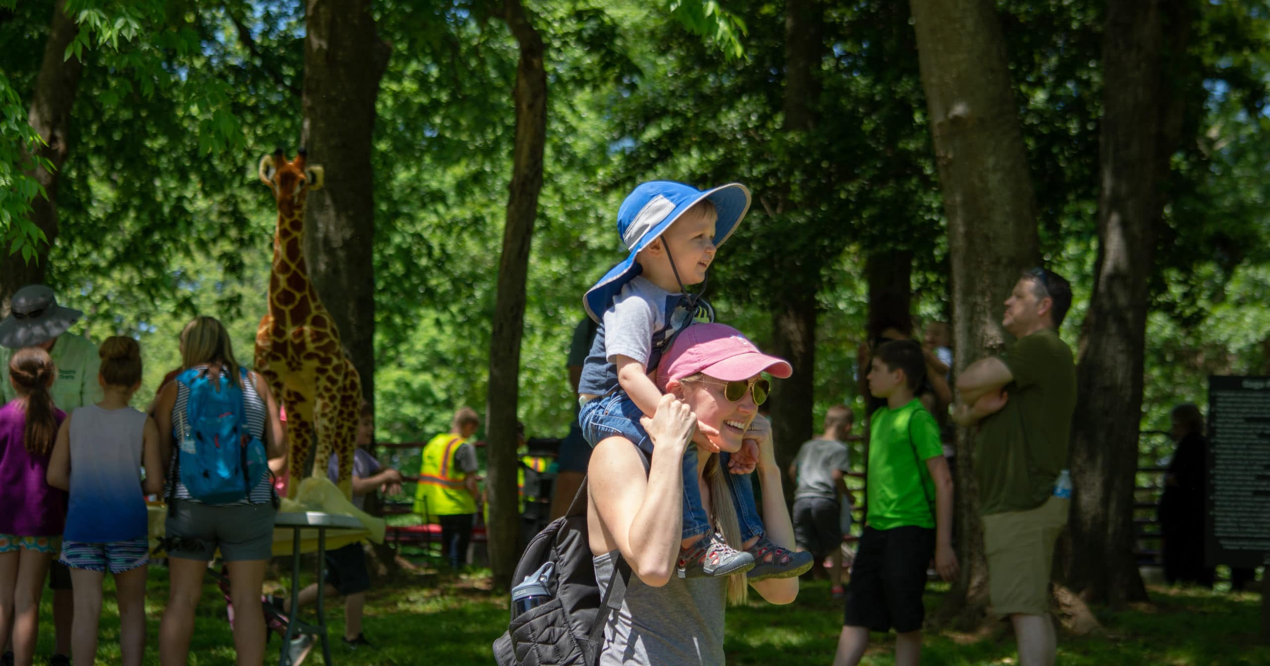 Mother holding her young son on her shoulders at the Earth Day Celebration at the Anne Springs Close Greenway