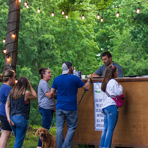 Concertgoers ordering drinks at the Summer Concert Series Bar at the Anne Springs Close Greenway
