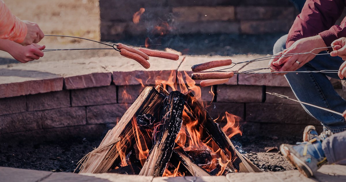 campers roast hotdogs over campfire at the Anne Springs Close Greenway fire ring