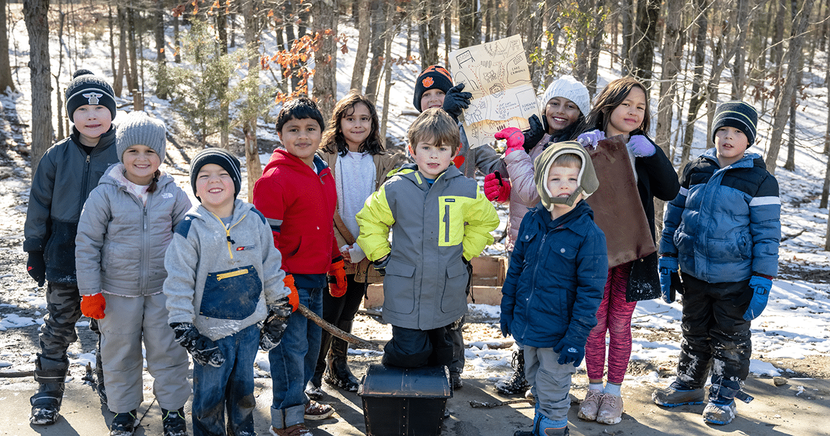 a group of children stands for a photo in winter gear on a cold day at anne springs close greenway