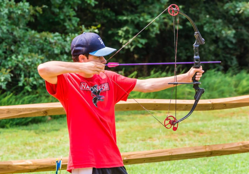 alt=Photo of teen boy practicing archery at the Anne Springs Close Greenway