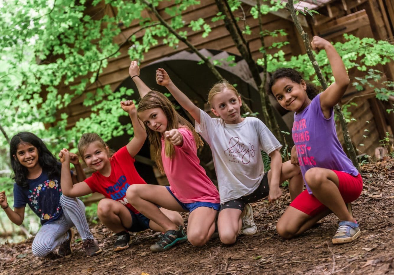 Photo of 5 young girls flexing their arms at Anne Springs Close Greenway's Summer Camp