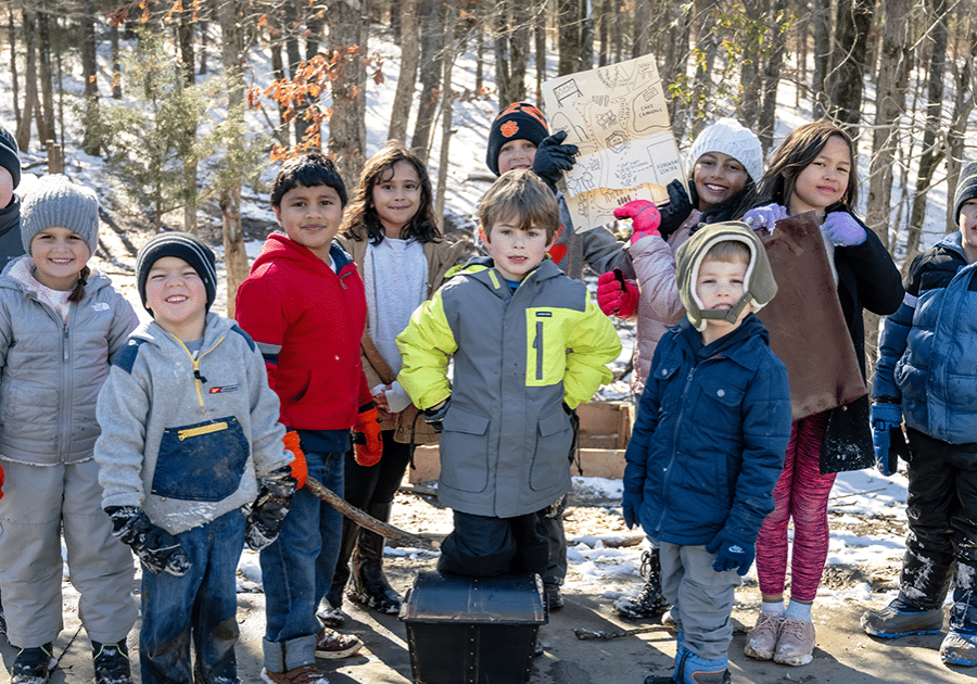 a group of children stands for a photo in winter gear on a cold day at anne springs close greenway